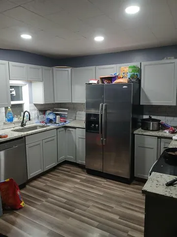 a kitchen with stainless steel appliances granite countertop a refrigerator sink and cabinets