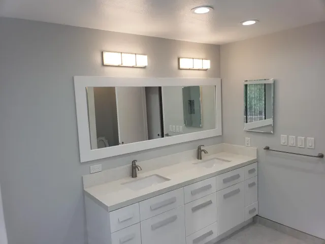 a bathroom with double sink and a mirror
