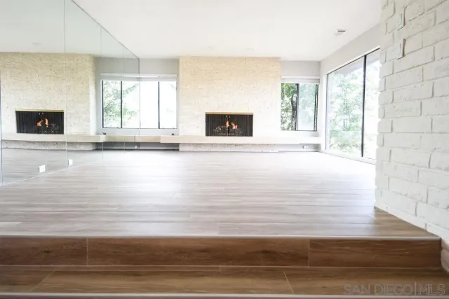 a view of a living room with hardwood floor and a fireplace