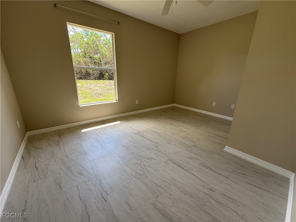 4547 21st Street Southwest Lehigh Acres, FL 33973 - Photo 6 of 12 an empty room with wooden floor and windows