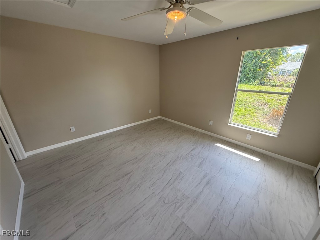 4547 21st Street Southwest Lehigh Acres, FL 33973 - Photo 7 of 12 an empty room with wooden floor and windows