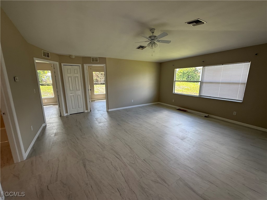 4547 21st Street Southwest Lehigh Acres, FL 33973 - Photo 10 of 12 an empty room with wooden floor and windows