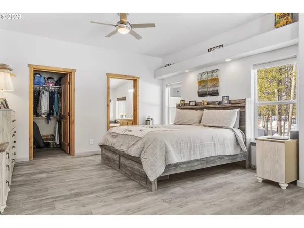 a bedroom with a large bed a chandelier and a window