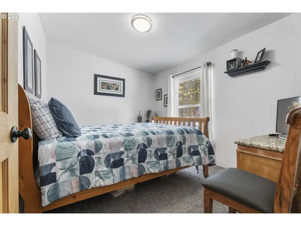 a bedroom with a bed dresser and a window