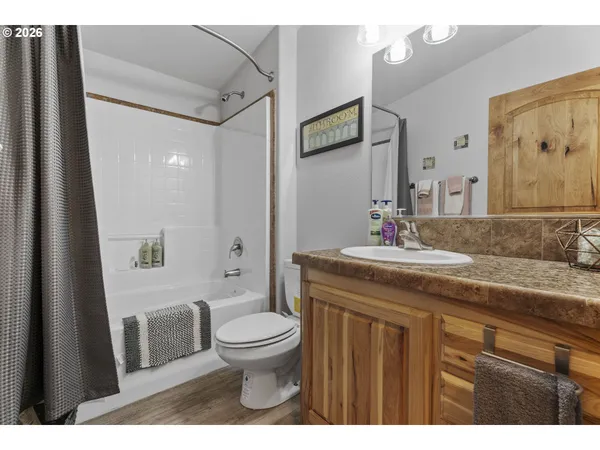 a bathroom with a granite countertop sink toilet a mirror a vanity and shower