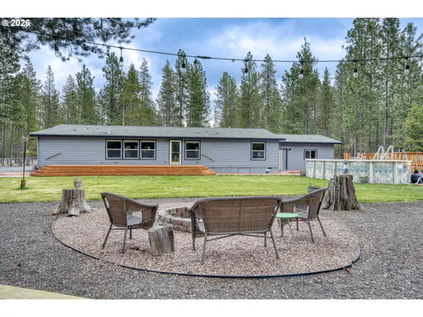 a swimming pool with outdoor seating yard and trees