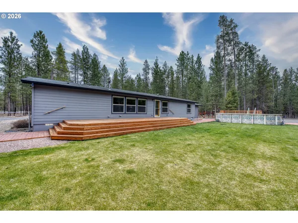 a view of a house with backyard and trees