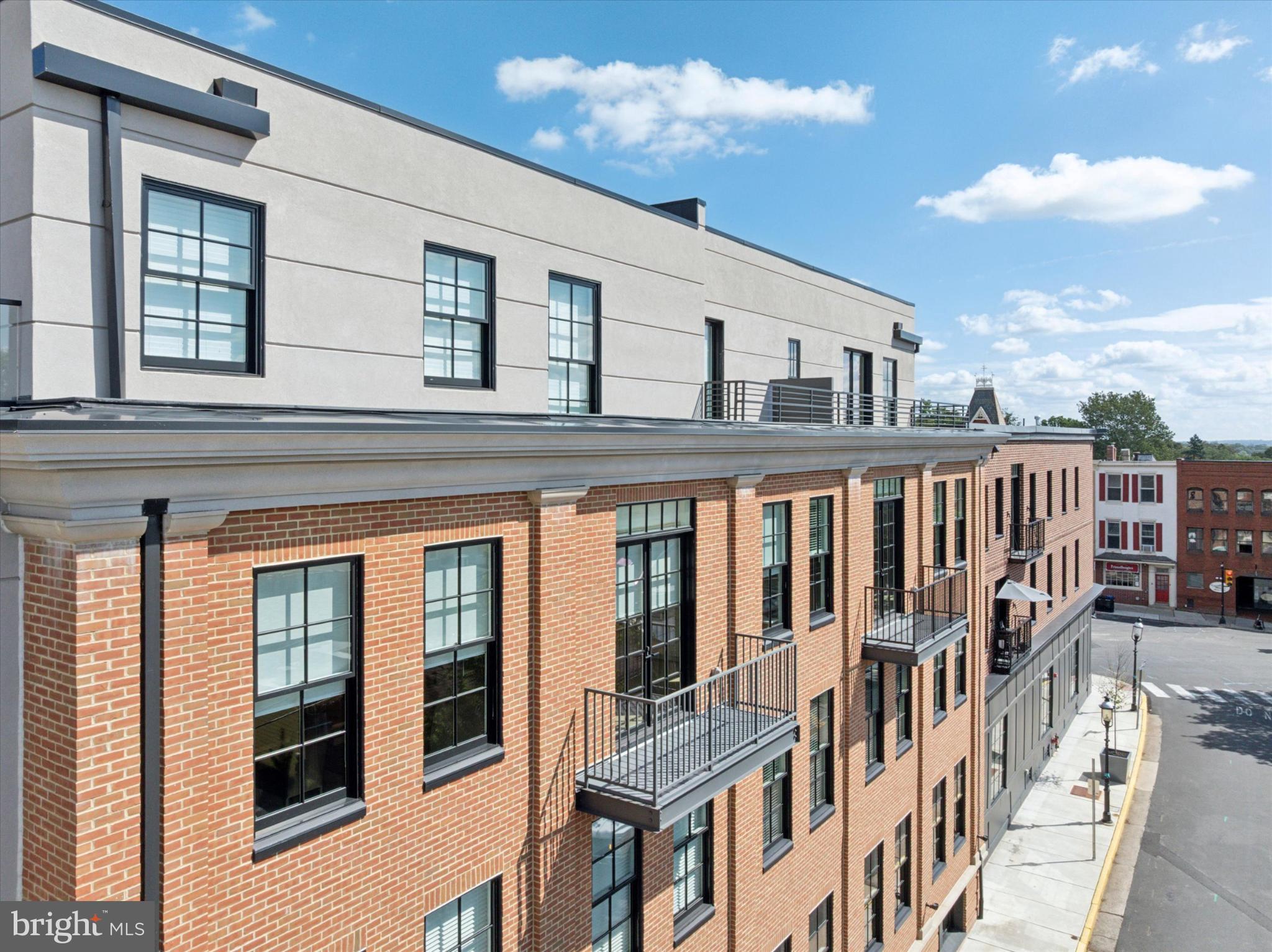 50 North Main Street, Unit 302 Doylestown, PA 18901 - Photo 28 of 33 a view of a brick house with a large window and wooden floor