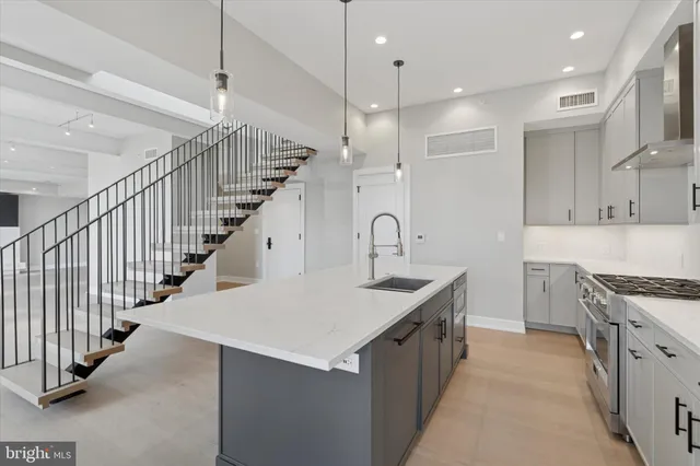 a kitchen with kitchen island a sink a stove a refrigerator and a counter top space
