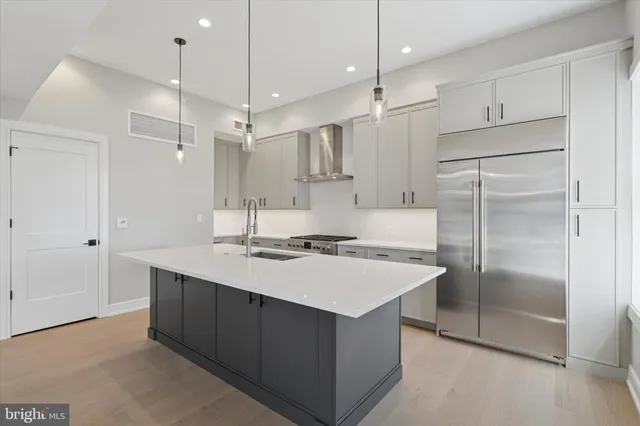 a kitchen with kitchen island a sink appliances and a counter top space