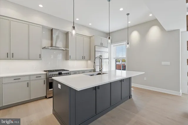 a kitchen with a sink a stove a refrigerator and white cabinets