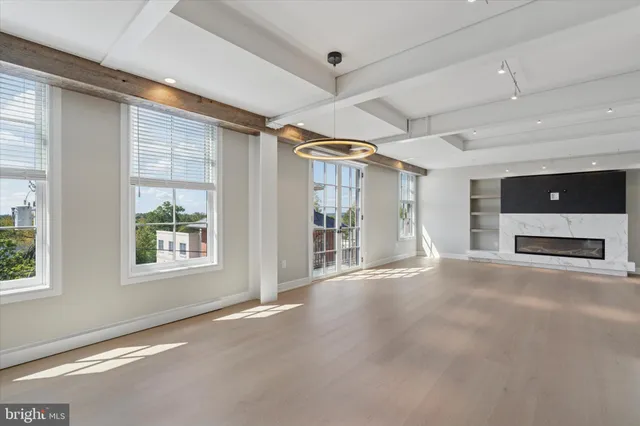 an empty room with windows fireplace and windows
