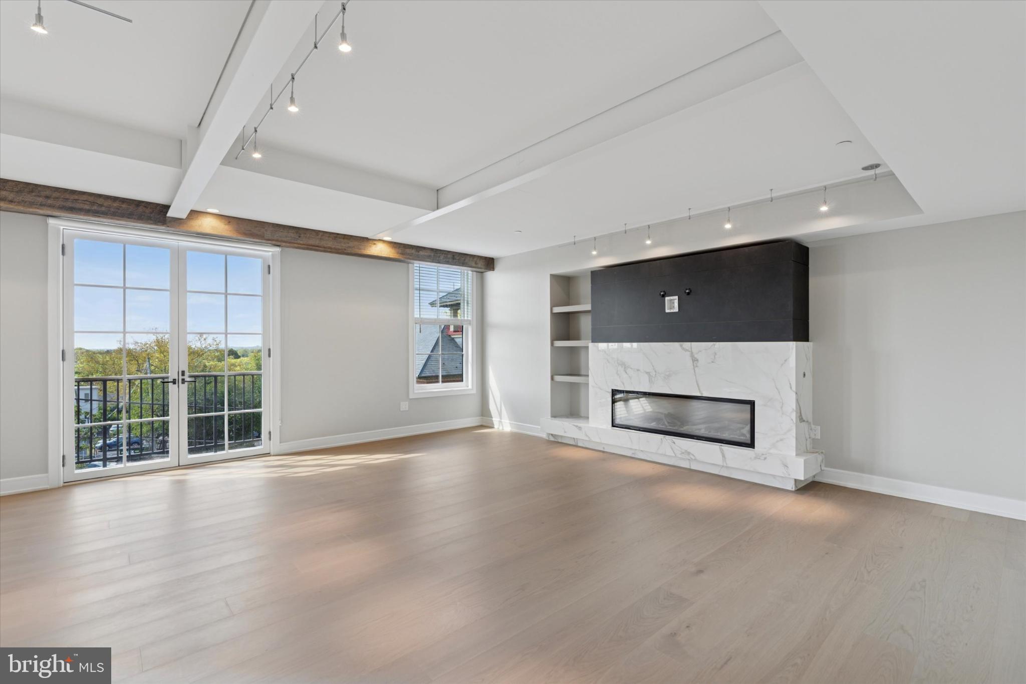50 North Main Street, Unit 302 Doylestown, PA 18901 - Photo 9 of 33 an empty room with windows fireplace and windows