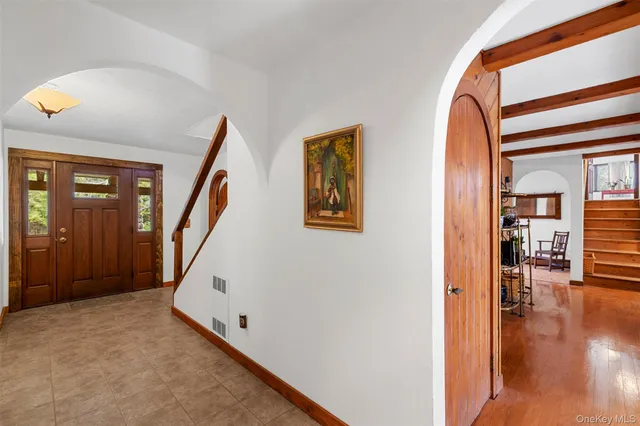 a view of a hallway with wooden floor and entryway
