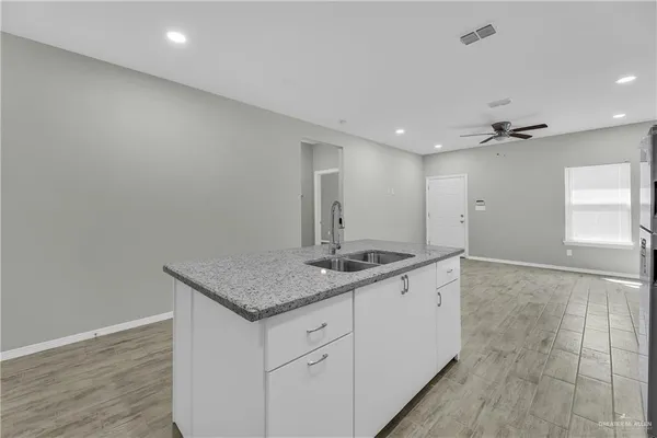 a bathroom with a granite countertop sink a toilet and a mirror