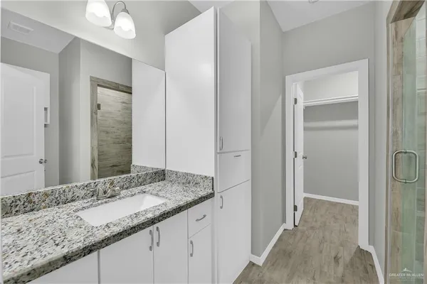 a bathroom with a granite countertop sink and a mirror