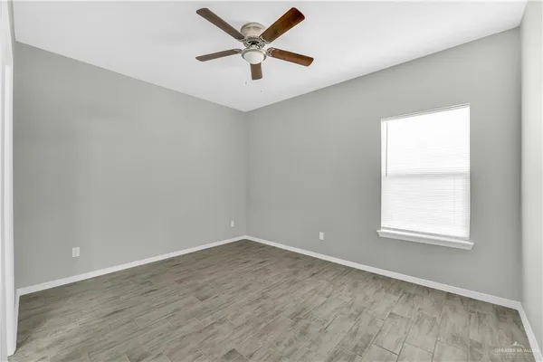 an empty room with a window and a fan