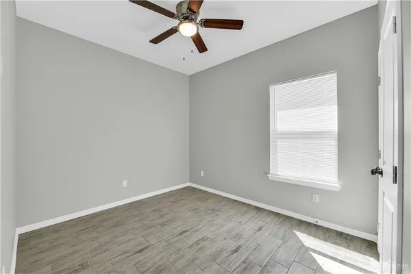 an empty room with a window and a fan