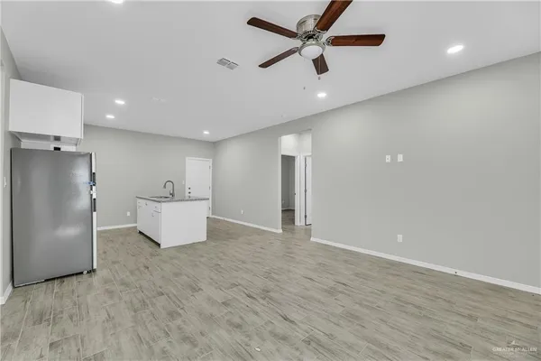 a view of an empty room with a kitchen