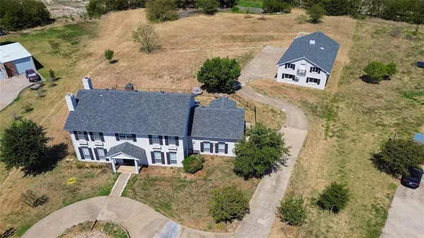 an aerial view of a house with a yard and lake view