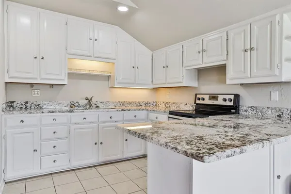 a kitchen with granite countertop white cabinets and a granite counter tops