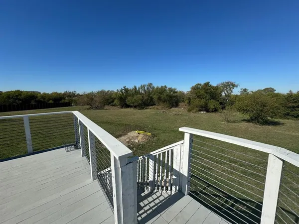 a view of a balcony with wooden floor and fence