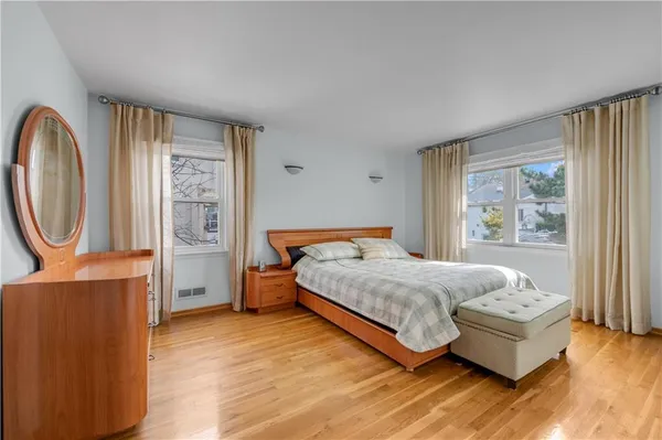 a bedroom with a bed wooden floor and window