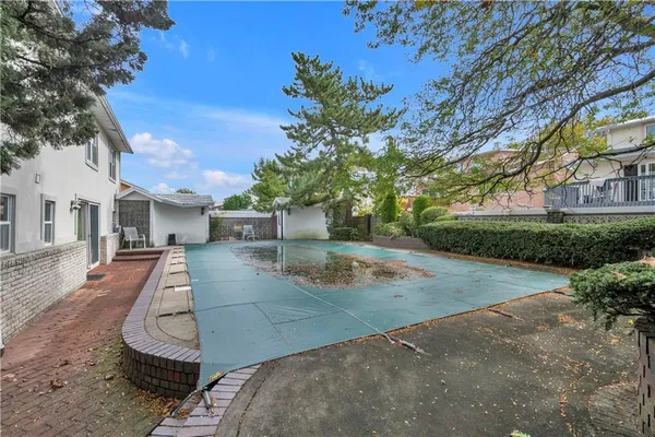 a view of a backyard with couches plants and large tree