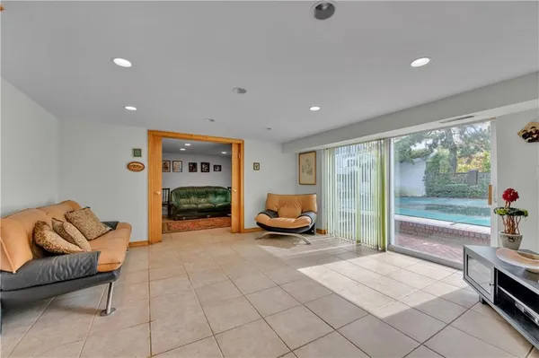 a living room with furniture a table and a large window