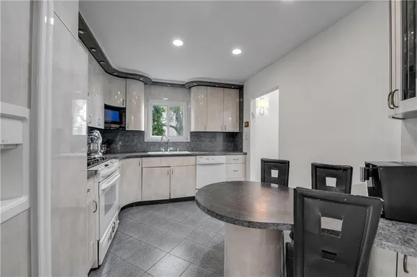 a kitchen with stainless steel appliances granite countertop a sink a stove and a refrigerator