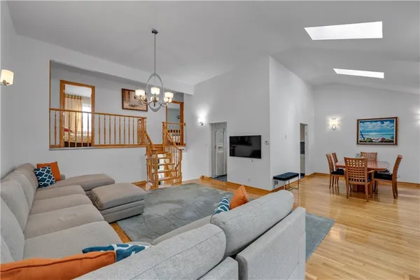 a living room with furniture a dining table and a chandelier