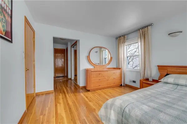 a bedroom with a bed a mirror and a window