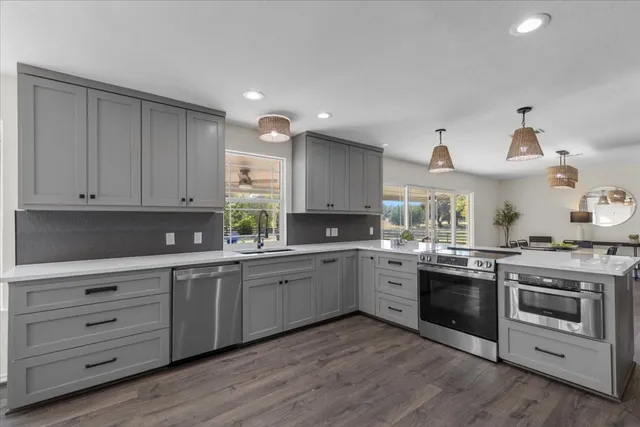 a kitchen with a stove a sink and wooden floor