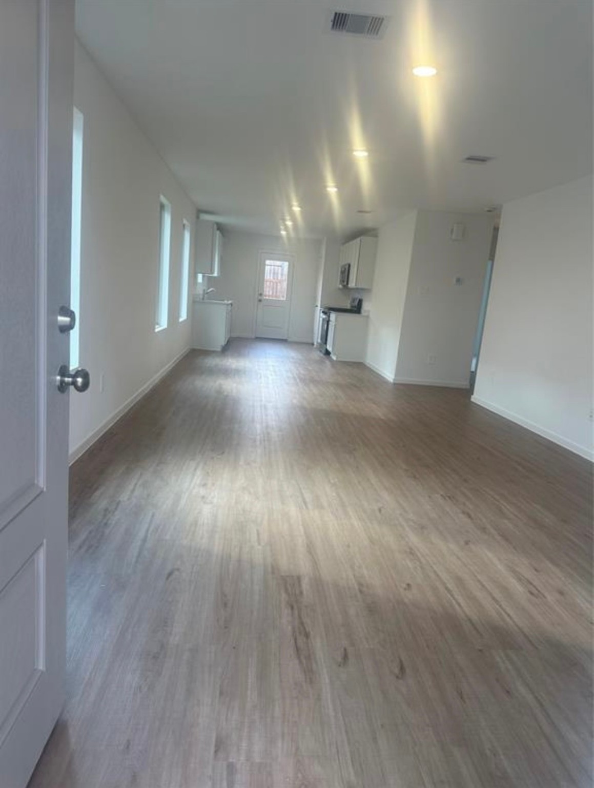 2621 Castille Valley Place Conroe, TX 77301 - Photo 3 of 10 an empty room with wooden floor and windows