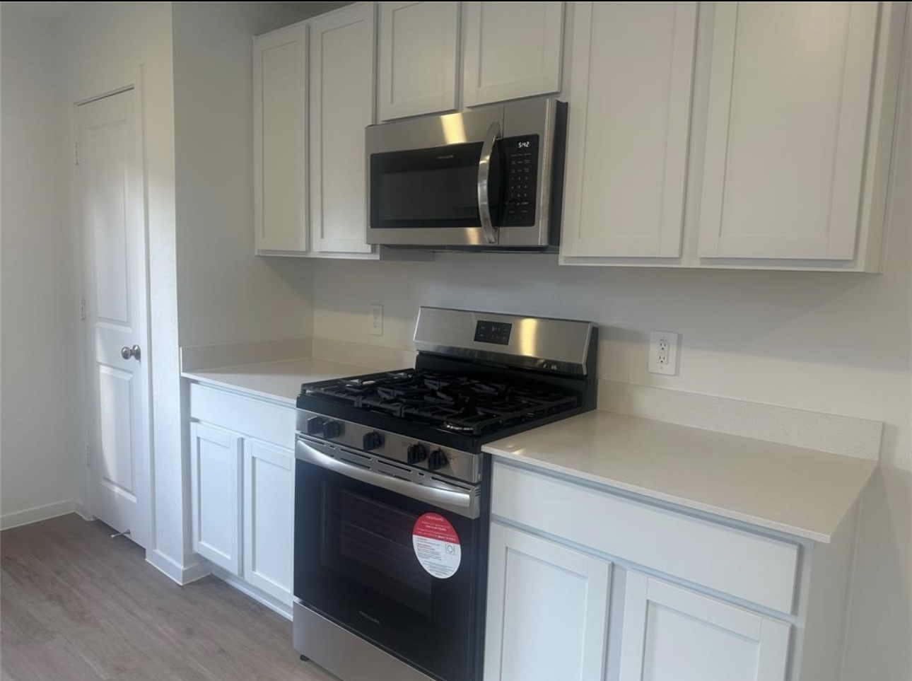 2621 Castille Valley Place Conroe, TX 77301 - Photo 4 of 10 a kitchen with stainless steel appliances granite countertop white cabinets and a stove top oven