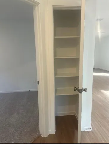 a view of walk in closet with empty racks