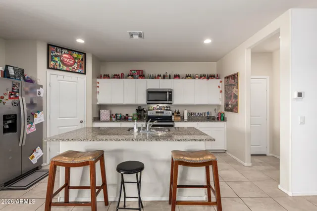 a kitchen with a dining table chairs and refrigerator