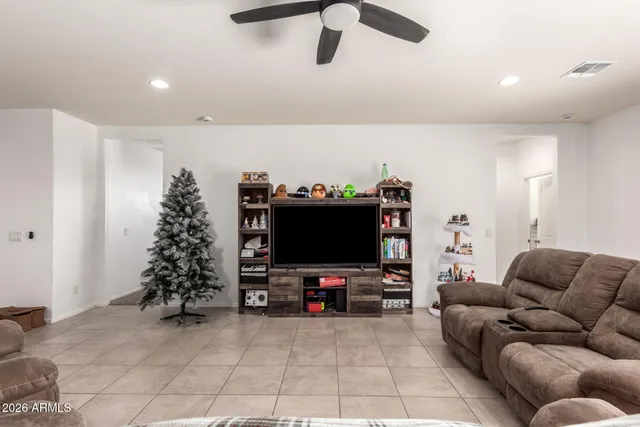 a living room with furniture a flat screen tv and kitchen view