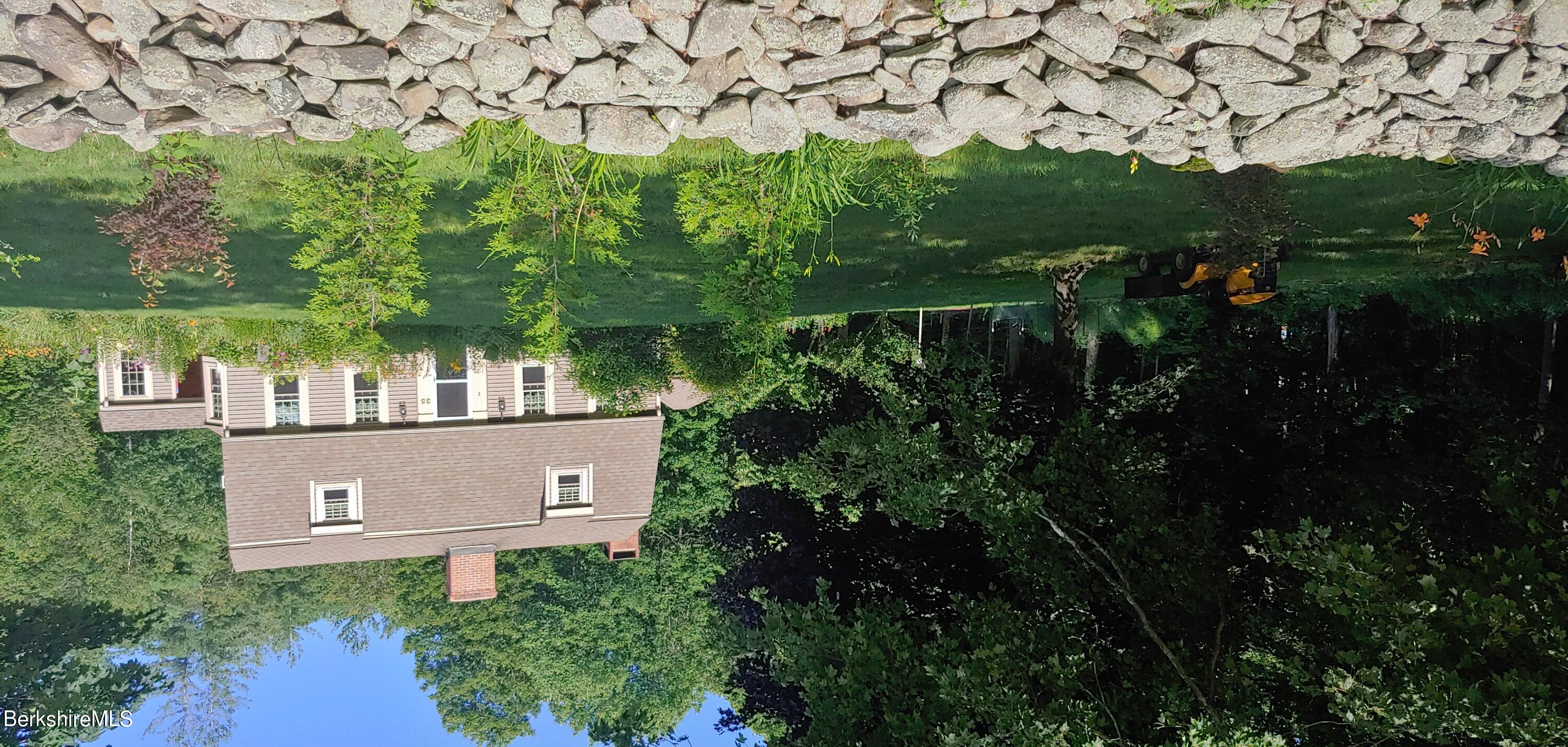 a view of house with yard and trees in the background