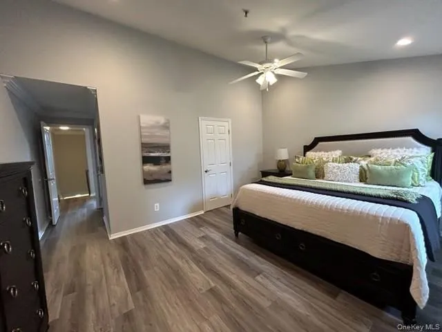 a bedroom with a large bed a chandelier and dresser