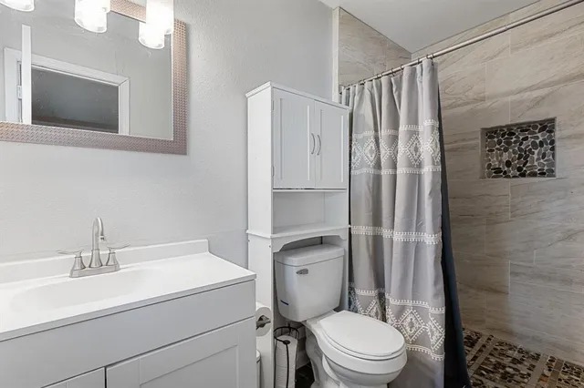 a bathroom with a toilet a sink and a shower