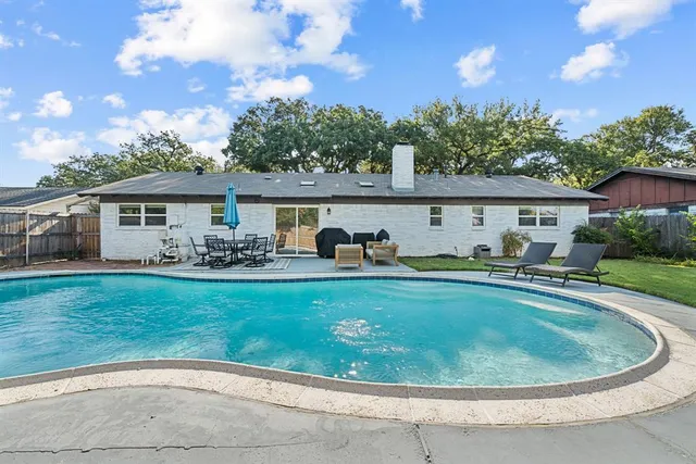 a view of swimming pool and trees in the background