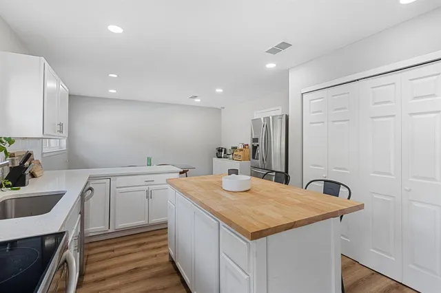 a kitchen with a sink a stove a refrigerator and cabinets