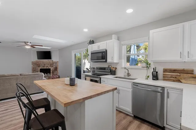 a kitchen with a stove a sink a microwave a dining table and chairs