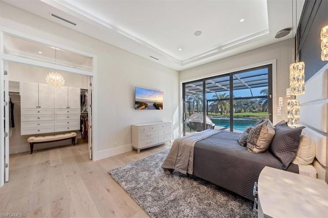 a bedroom with a bed and large windows