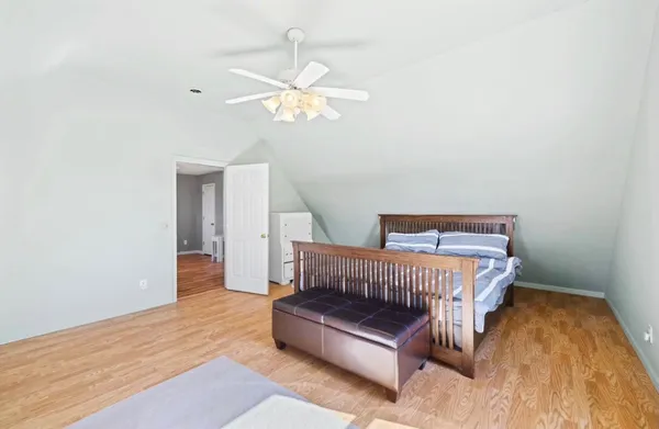 a spacious bedroom with a bed and a chandelier