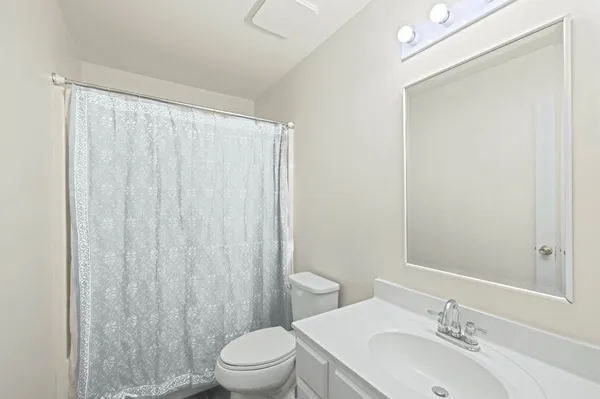 a bathroom with a sink a toilet and shower curtain