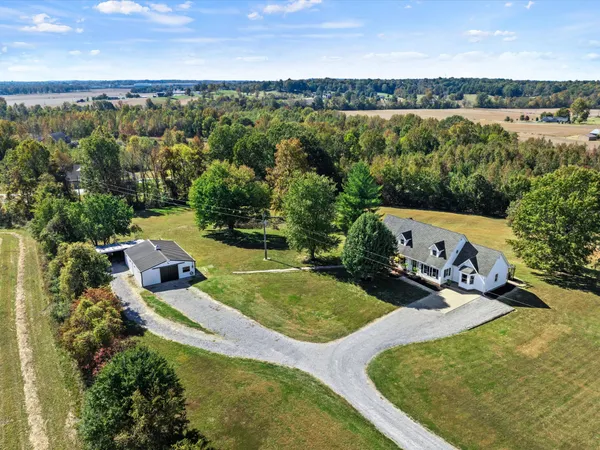 an aerial view of a house with a garden and lake view