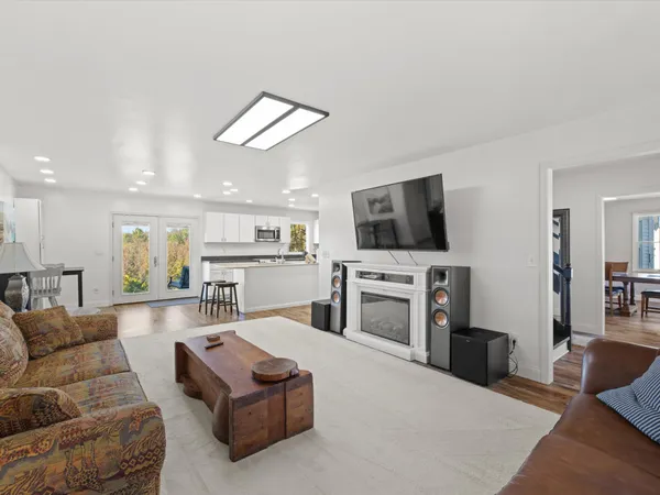 a living room with furniture a flat screen tv and kitchen view