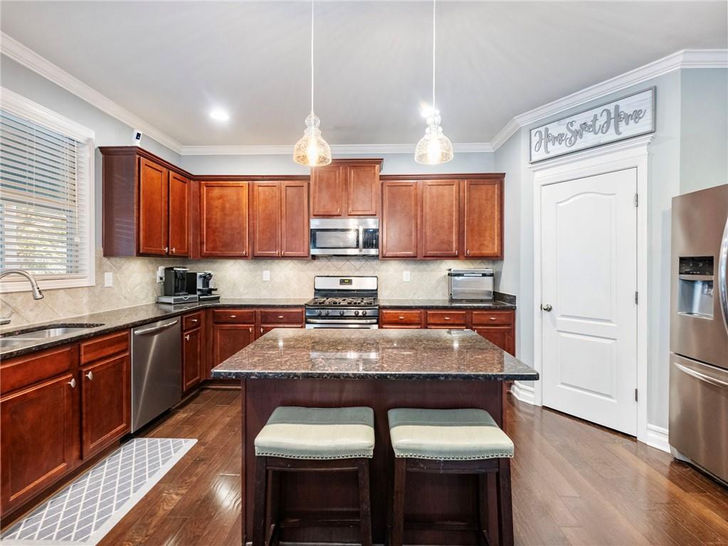 2939 Estate View Court Dacula, GA 30019 - Photo 17 of 73 a kitchen with stainless steel appliances wooden cabinets granite counter tops a stove a sink and a refrigerator